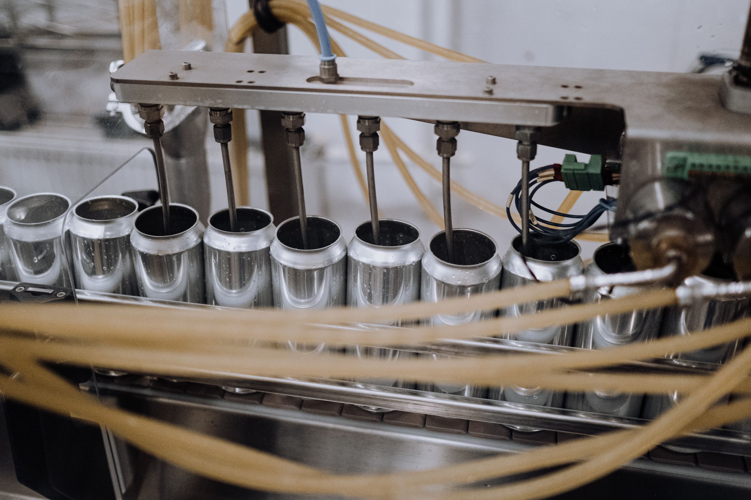 Robotic arms filling cans of soda.